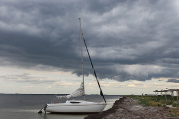 sailing boat on the beach on the storm clouds background 