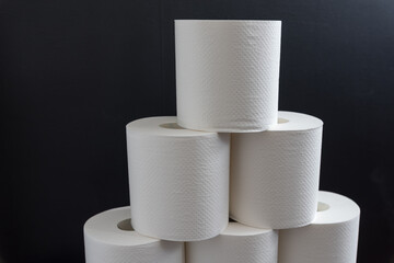 積み上げたトイレットペーパーと黒い背景