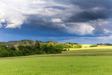 Dramatic sky over green field. rain before. Agricultural landscape in the Czech Republic. Dark rain clouds.