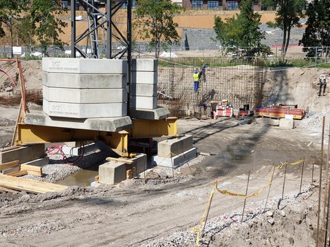 Construction site with crane and concrete blocks holding it's bottom.