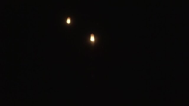 Low angle view of sky lanterns flying against sky at night - Luang Phabang, Laos