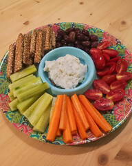 party platter with different kinds of vegetables and cheese salad on a colorful plate 