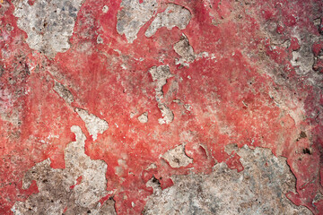 Texture of old peeling paint of red color on a concrete wall. Abstraction for the desktop.