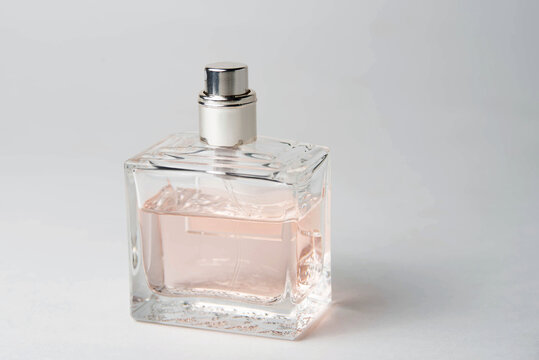pink women's perfume bottle in a rectangular glass bottle on a white background