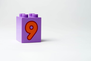 the number nine written on the block from the children's constructor