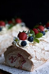 Meringue roll with strawberries and blueberries