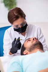 Young man visiting female beautician in hair transplantation con