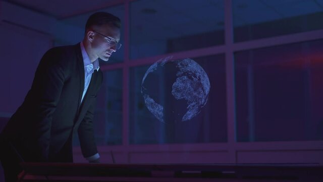 The businessman working with a virtual holographic globe