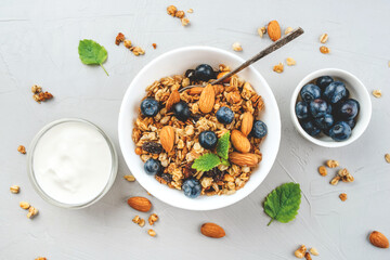 Baked granola with yogurt and blueberries on a gray table. Top view.