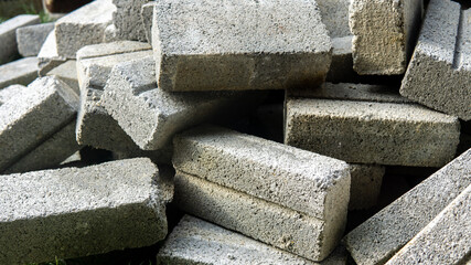 Close up detail view of a pile of bricks on the ground used for house renovation. Bricks usually use in building construction, civil engineering work and landscape design.