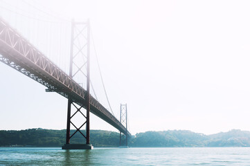 25th April Bridge on Tejo river at misty day in Lisbon, Portugal. Summer landscape. Famous travel destination