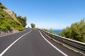 Fototapeta premium Empty curved coastal road on sunny day