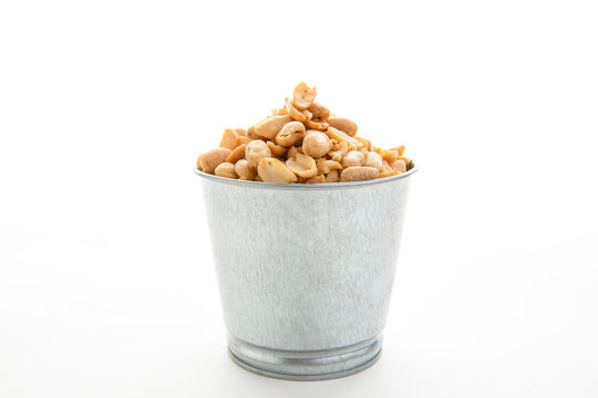A pile of peanuts in a separate color cup on a white ground