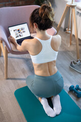 Fototapeta na wymiar Young sporty slim woman has internet video online fitness training, modern laptop screen. Healthy lifestyle concept, online fitness and sport lessons. Preparing for the training.