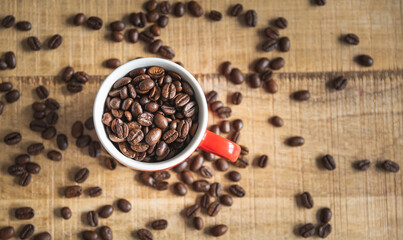 A cup full of coffee beans on a wooden mangocoffee table