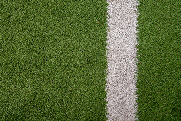 Fototapeta premium Artificial grass background on a soccer field with a stripe in its side