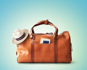 Vacation concept, large classic brown leather travel bag with hat