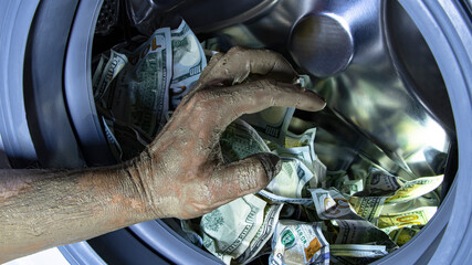 Money laundering. Corruption Concealment of taxes. Dollars in the drum of a washing machine and dirty male hand. Concept for social advertising.