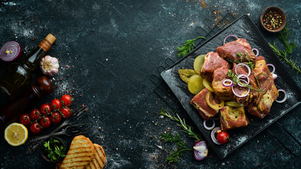 Meat. Raw marinated kebab with onions and spices on a black plate. Top view. Free copy space.