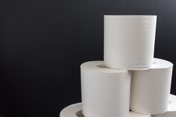 積み上げたトイレットペーパーと黒い背景