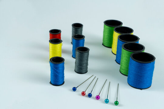 Colored pins in a red paralon pad and threads isolated
