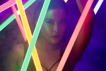 Face Close up of High Fashion Trend Cosmetic make up with NEON tube light, effect on skin of young...