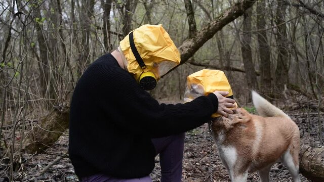 Man holding his dog, Huskey, in Yellow Radiation mask, coronavirus concept