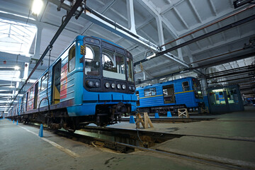 Fototapeta premium At the maintenance hall: subway trains parked on pits for technical inspection