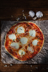 pizza on a newspaper and a wooden Board, top view