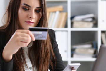 Business woman in the office holds a plastic credit debit card in her hand