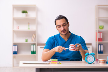Young male dentist working in the clinic