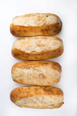 Fototapeta na wymiar French bread rolls in a row isolated on light background.