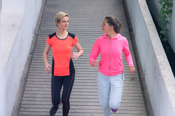 Two Healthy young female sporty women running in morning on street. Runner training outdoors in morning.