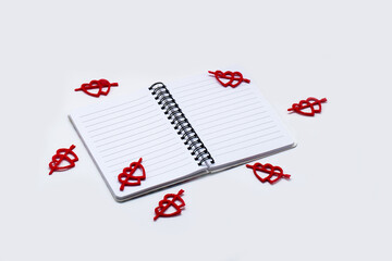 Valentines Day background, colorful decoration design with space for text. White notebook with a red hearts, top view concept. Romantic concept, flat lay.