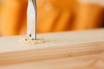 Flat drill bit make hole in wooden bar closeup