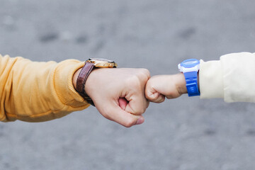 A selective focus of a fist bump between the old and the kid for senses of encouragement and...