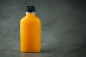 Vertical of fresh orange juice in a plastic bottle