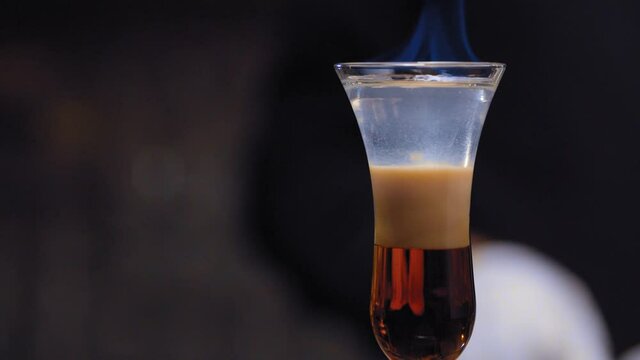 Close up burning cocktail B-52 slowly moving on slider. Strong sweet short drink. Bar drinks series.