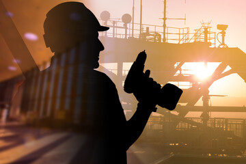 Man works petroleum production platform. Silhouette worker with screwdriver. Concept - crude oil...