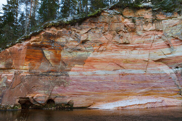 Sandstone cliffs exposed along the river. Winter season. Estonia.