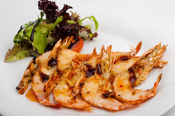 Spicy prawns with salad on a white plate