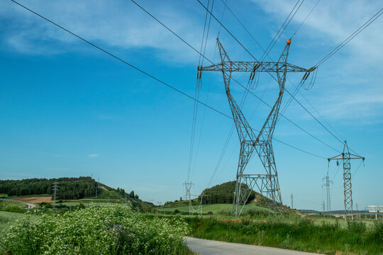 Paisaje de prados verdes en verano con tendido el&eacute;ctrico.