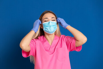 Young doctor wearing a mask face and a pink uniform