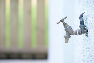 Bib tap outdoors on house external wall to water garden and car