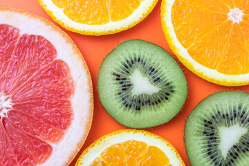 Fresh fruit background, citrus colorful pattern. Slice of kiwi, orange and grapefruit on bright background. Exotic tropical fruits close-up.