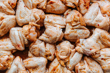 Raw Marinated chicken meat wings in a marinade.