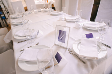 Presidium, banquet table with a white tablecloth. Plates and cutlery, glasses, napkins.