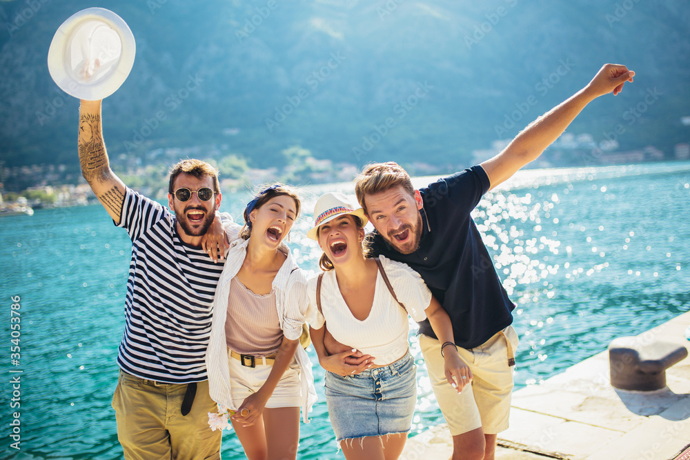 Wall mural group of friends having fun near the sea on vacation