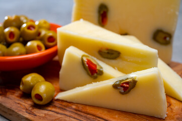 Cheese collection, fresh Italian pecorino cheese made from sheep milk filled with green olives stuffed with red paprika