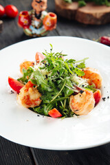 Gourmet arugula shrimp salad in a white plate